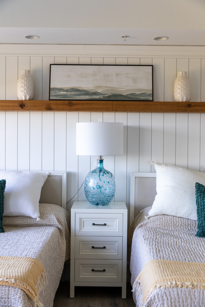 Idée de décoration pour une chambre parentale marine de taille moyenne avec un mur blanc, un sol en bois brun, un manteau de cheminée en bois, un sol gris, un plafond décaissé et du lambris de bois.