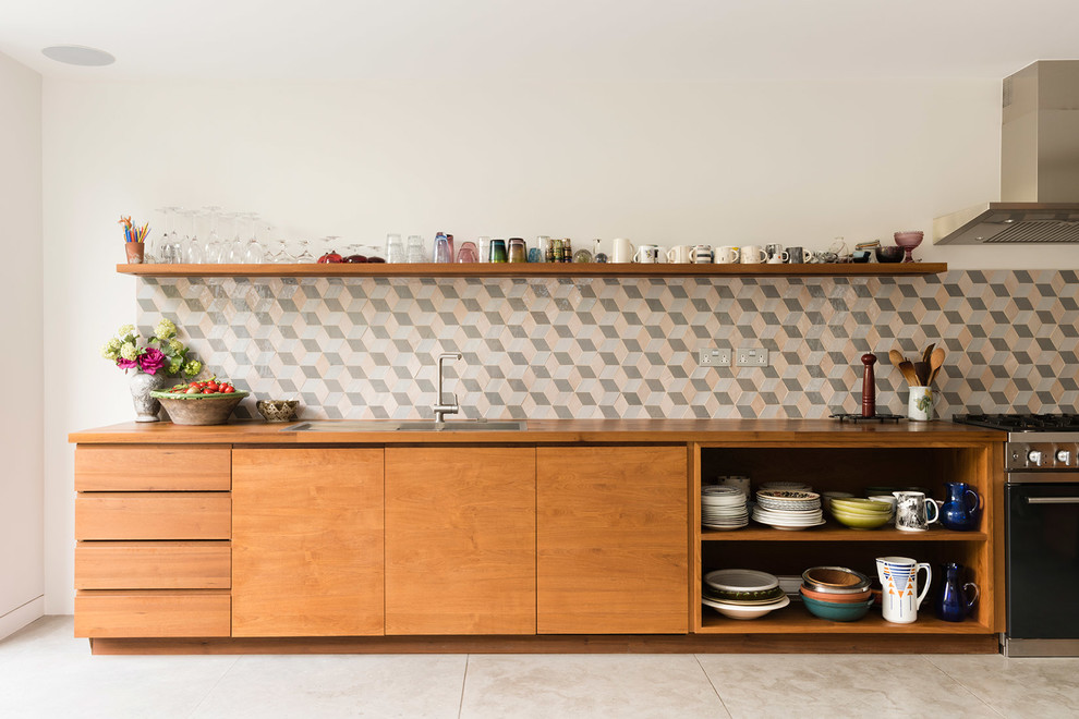 Contemporary single-wall kitchen in London with a double-bowl sink, flat-panel cabinets, medium wood cabinets, wood benchtops, mosaic tile splashback, no island, grey floor and brown benchtop.