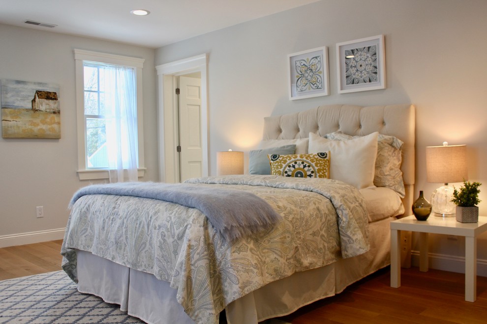 Design ideas for a mid-sized transitional master bedroom in Boston with blue walls, light hardwood floors, no fireplace and beige floor.