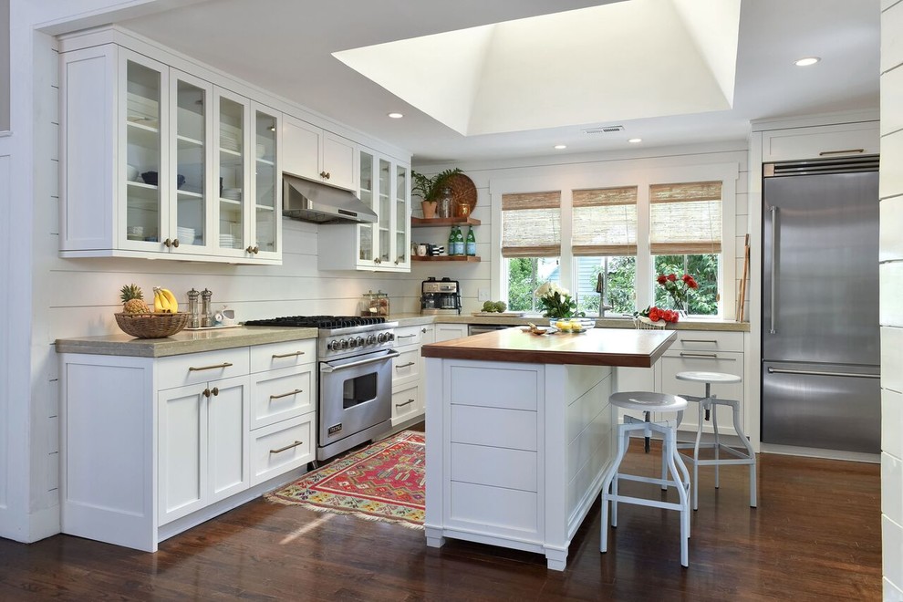 Design ideas for a large beach style u-shaped eat-in kitchen in Charleston with a farmhouse sink, shaker cabinets, white cabinets, limestone benchtops, white splashback, stainless steel appliances, dark hardwood floors and with island.