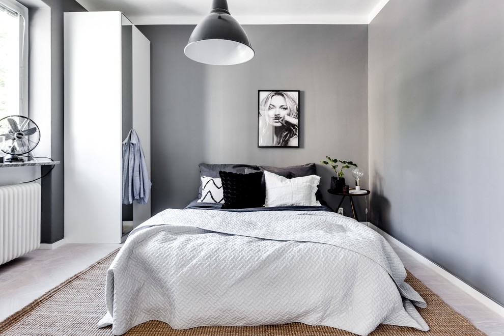 Inspiration for a mid-sized modern master bedroom in Stockholm with grey walls and light hardwood floors.