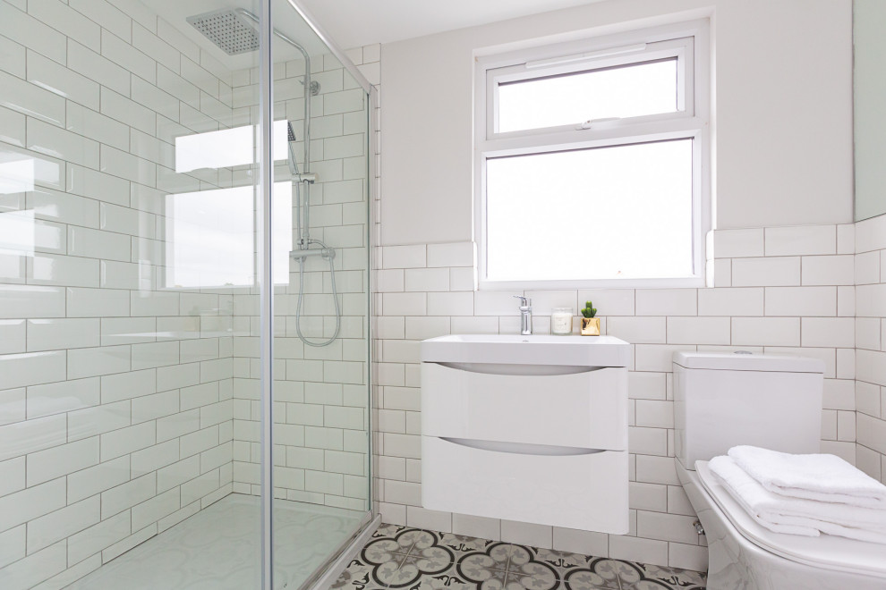 Design ideas for a transitional bathroom in London with flat-panel cabinets, white cabinets, an alcove shower, white tile, subway tile, white walls, a console sink, multi-coloured floor, white benchtops, a single vanity and a floating vanity.
