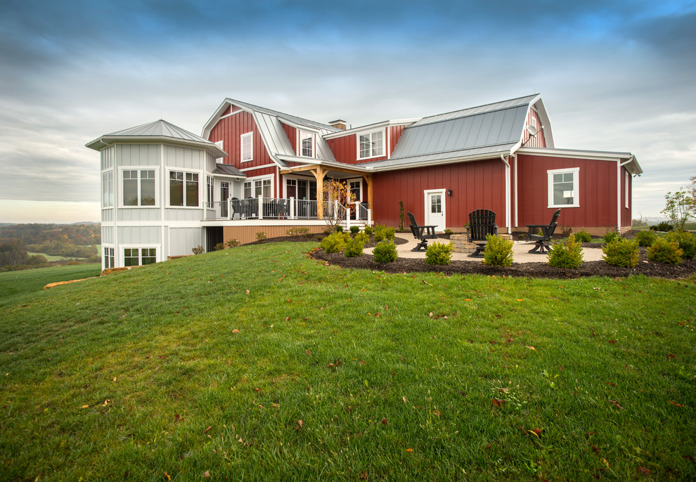 This is an example of a country two-storey red exterior in Columbus with a gambrel roof.
