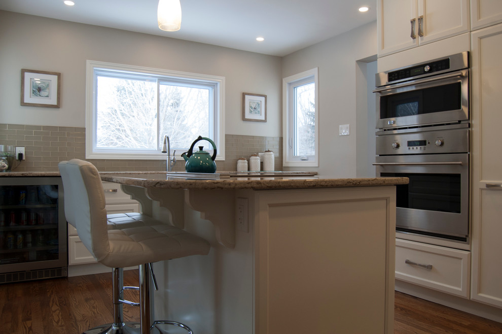 Example of a transitional kitchen design in Ottawa with an island
