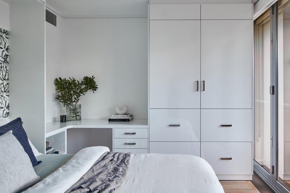 Inspiration for a contemporary study room in Sydney with white walls, laminate floors and a built-in desk.