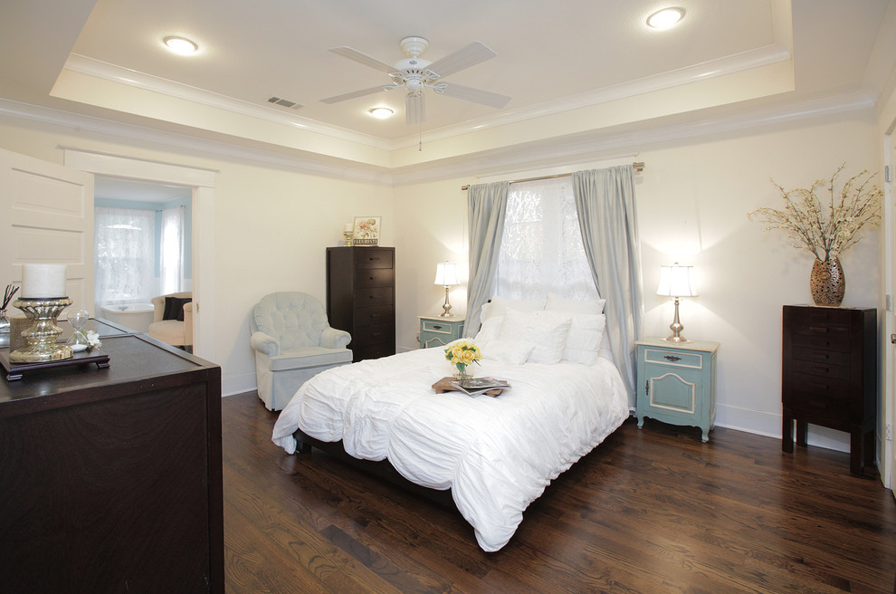 This is an example of a transitional bedroom in Dallas with white walls and dark hardwood floors.