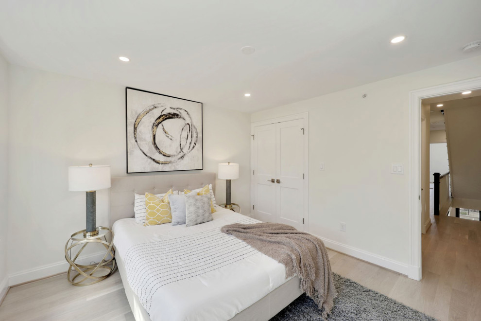 Photo of a contemporary guest bedroom in DC Metro with light hardwood flooring and brown floors.