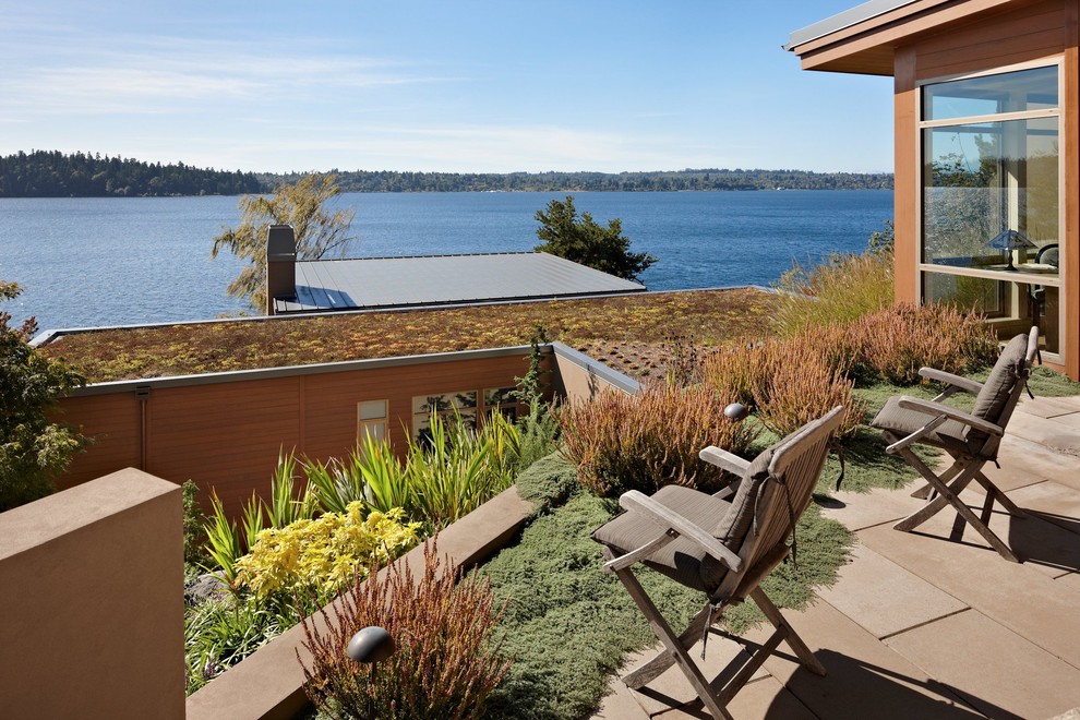 Modern exterior in Seattle with wood siding and a green roof.