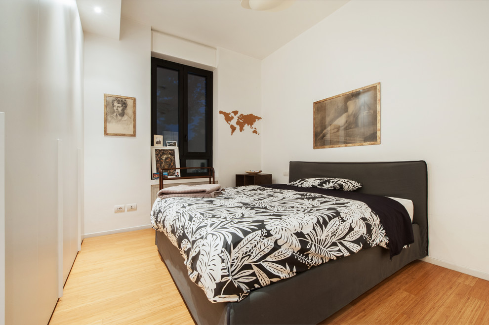 Design ideas for a contemporary master bedroom in Milan with white walls, light hardwood floors and beige floor.