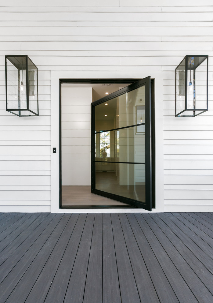 Photo of a large modern front door in Charleston with white walls, a pivot front door, a black front door and grey floor.