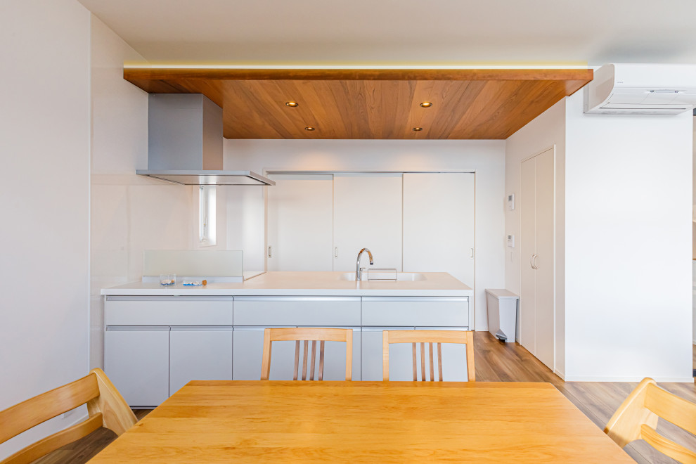 Inspiration pour une cuisine ouverte linéaire asiatique de taille moyenne avec parquet foncé, un sol marron et un plafond en lambris de bois.