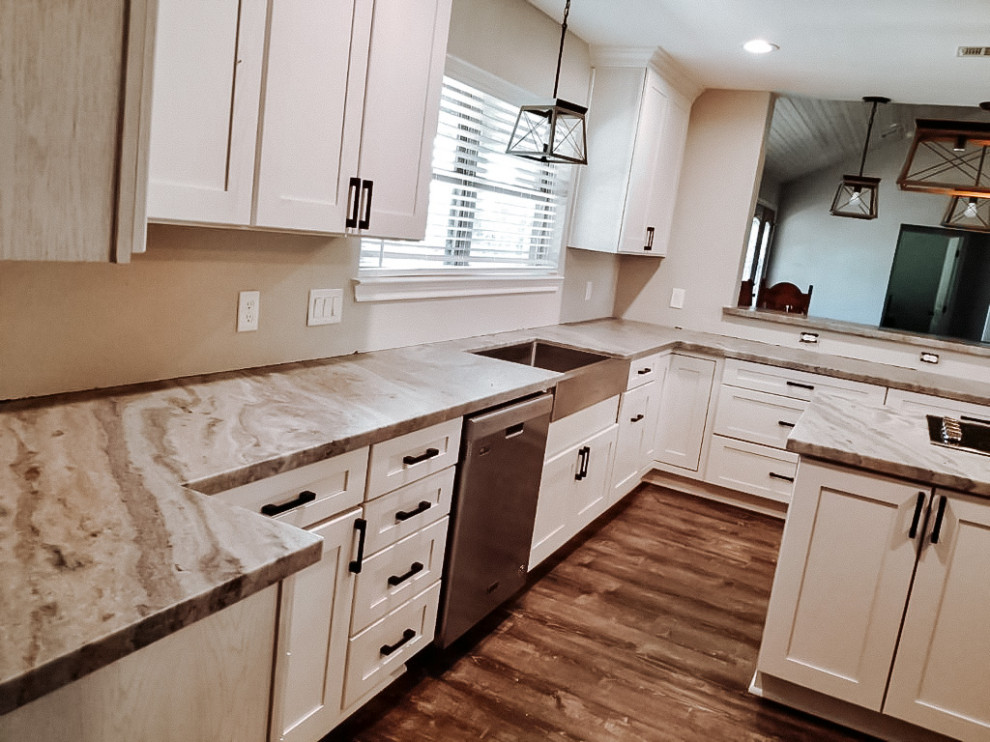 Large transitional l-shaped medium tone wood floor and brown floor eat-in kitchen photo in Houston with a farmhouse sink, shaker cabinets, light wood cabinets, stainless steel appliances, an island and gray countertops