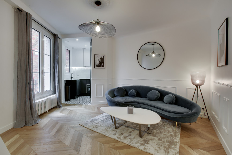 This is an example of a mid-sized contemporary open concept living room in Paris with white walls, light hardwood floors, a wall-mounted tv and decorative wall panelling.