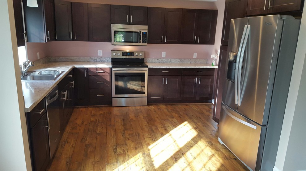 Example of a mid-sized transitional u-shaped enclosed kitchen design with a double-bowl sink, dark wood cabinets, laminate countertops, gray backsplash, stainless steel appliances, no island and shaker cabinets