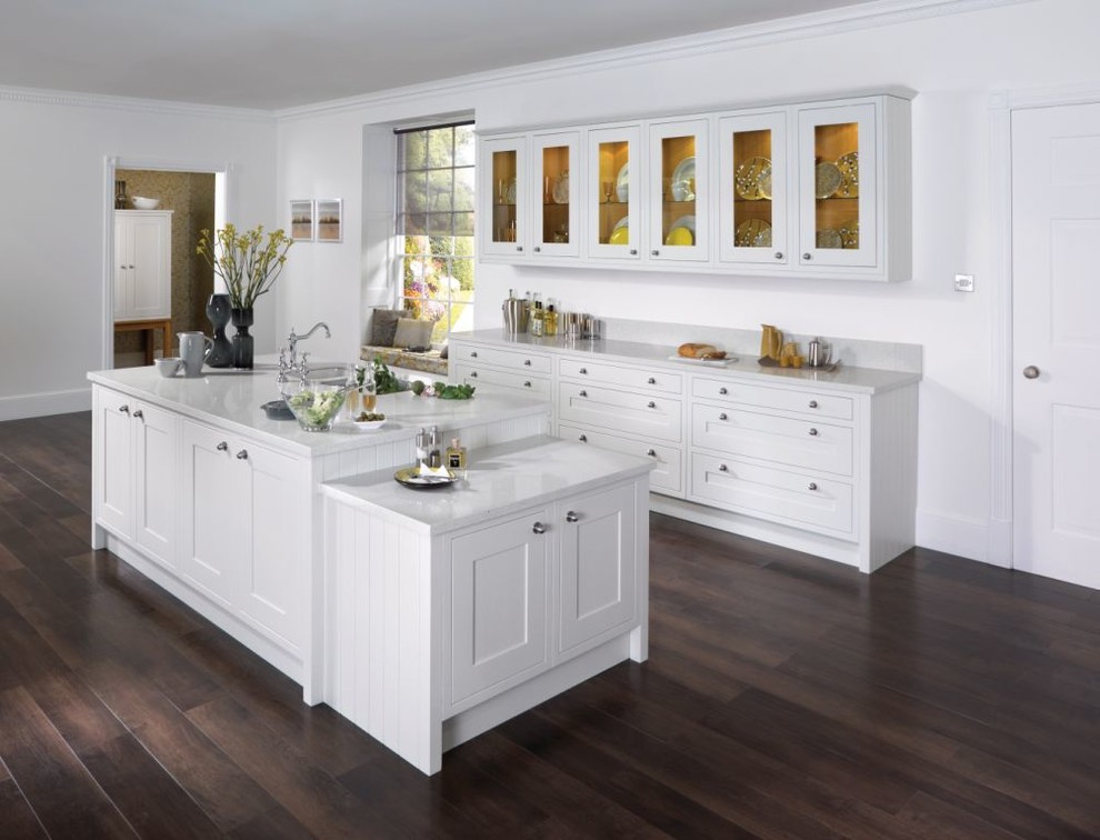 This is an example of a large contemporary single-wall kitchen in Miami with an undermount sink, recessed-panel cabinets, white cabinets, recycled glass benchtops, white splashback, dark hardwood floors and with island.