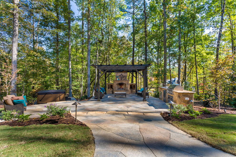 Expansive arts and crafts backyard patio in Raleigh with a fire feature, stamped concrete and a pergola.