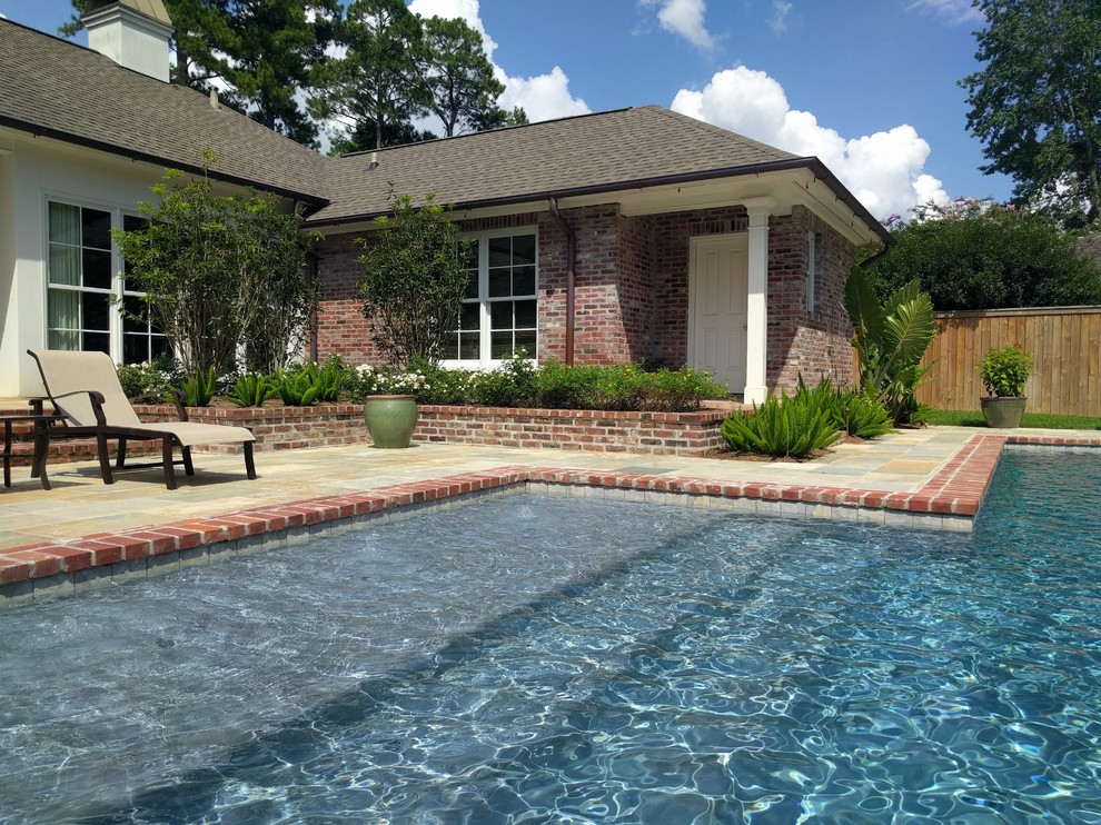 Photo of a mid-sized traditional backyard rectangular lap pool in New Orleans with a hot tub and natural stone pavers.