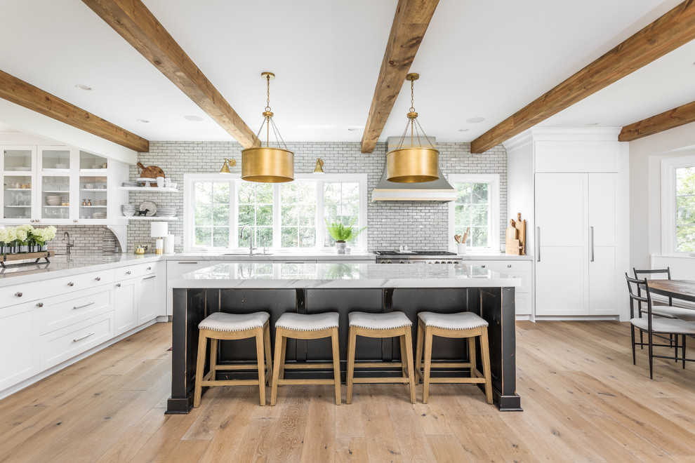 This is an example of a traditional l-shaped eat-in kitchen in Indianapolis with an undermount sink, shaker cabinets, white cabinets, grey splashback, subway tile splashback, stainless steel appliances, light hardwood floors, with island, beige floor and grey benchtop.