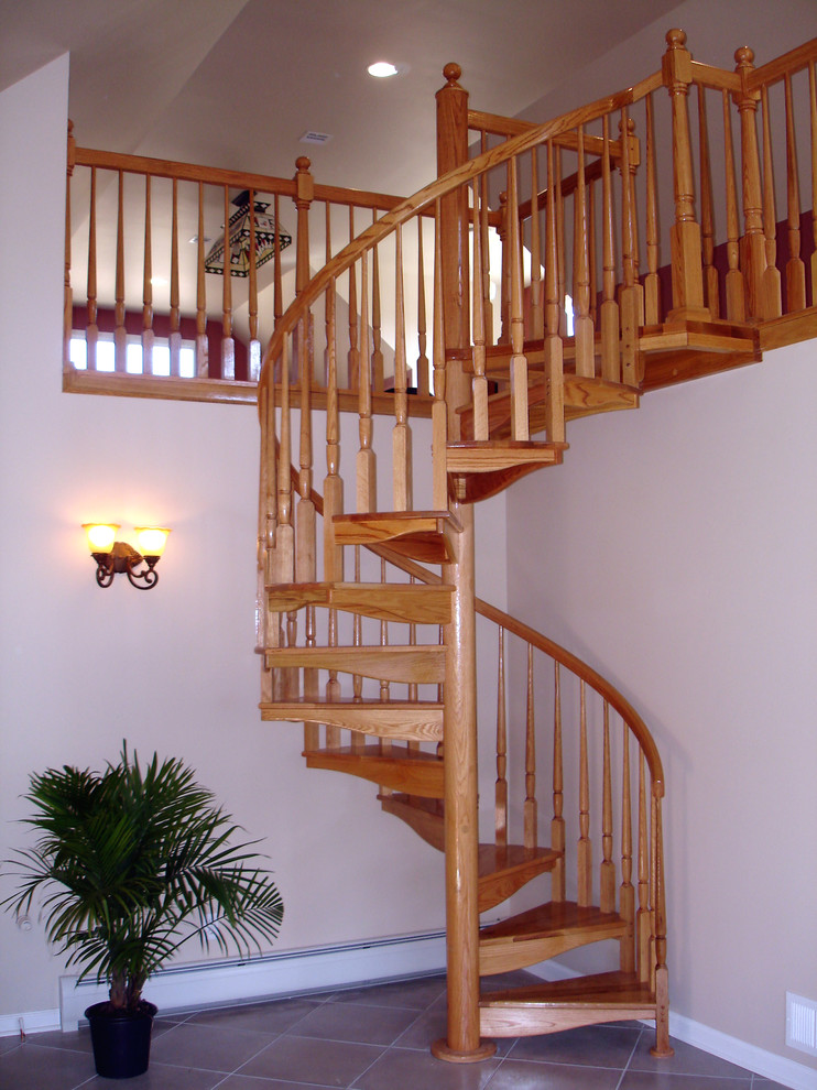 Photo of a mid-sized traditional wood spiral staircase in New York with wood risers.