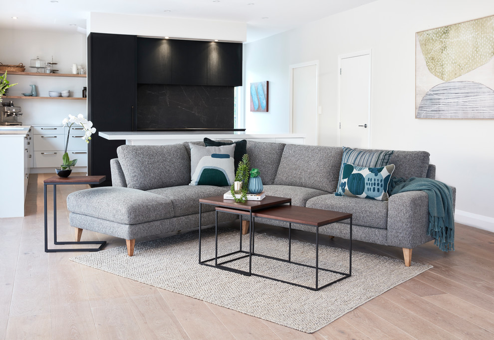 Photo of a Mid-sized contemporary Loft-style living room With Beige Walls, Light Hardwood Floors and No Fireplace.