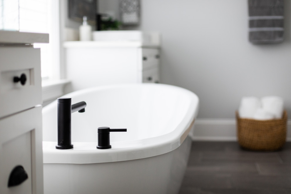 Inspiration for a transitional master white tile porcelain tile, gray floor and single-sink freestanding bathtub remodel with shaker cabinets, white cabinets, white walls, a vessel sink, quartz countertops, white countertops and a freestanding vanity