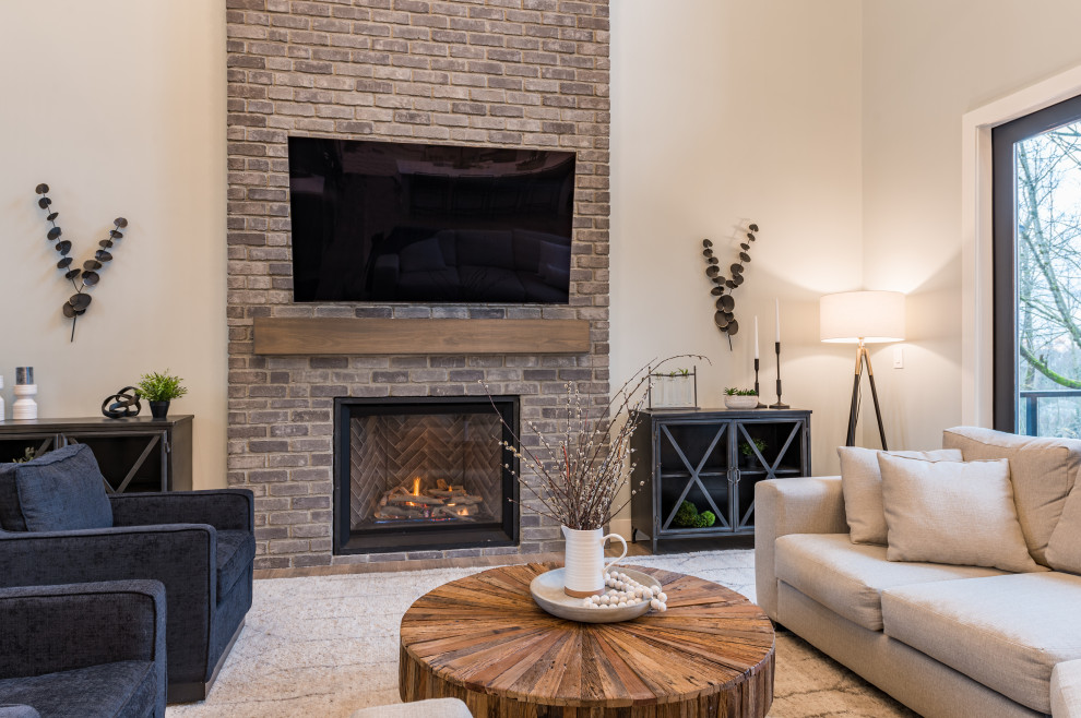 Large country open concept laminate floor, brown floor and brick wall living room photo in Vancouver with white walls, a standard fireplace, a brick fireplace and a wall-mounted tv