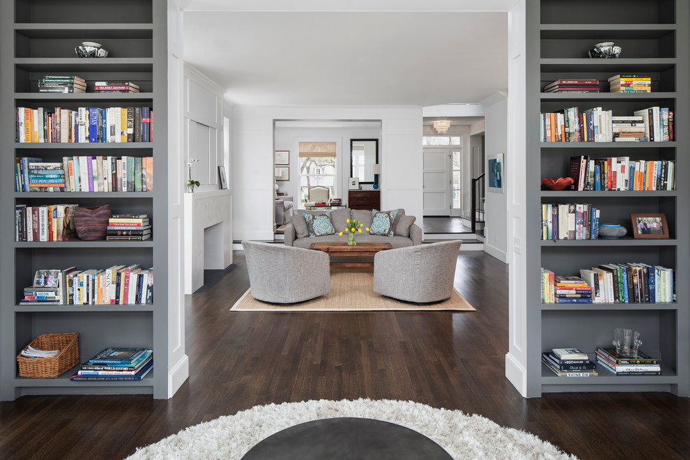 This is an example of a large transitional open concept family room in Austin with a library, white walls, dark hardwood floors, a standard fireplace, a plaster fireplace surround and no tv.