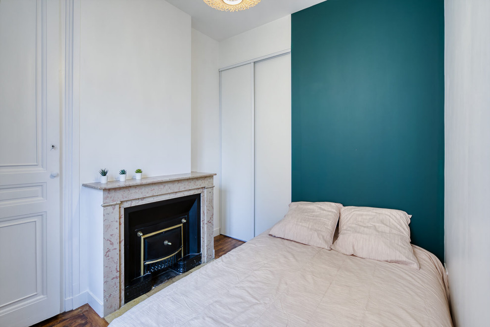 Kleines Skandinavisches Hauptschlafzimmer mit grüner Wandfarbe, braunem Holzboden, Kamin und Kaminumrandung aus gestapelten Steinen in Sonstige
