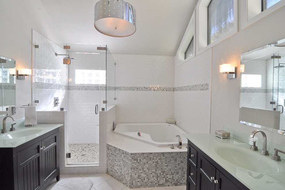 Inspiration for a transitional bathroom in Dallas with an integrated sink, shaker cabinets, dark wood cabinets, glass benchtops, a drop-in tub, an alcove shower, white tile and ceramic tile.