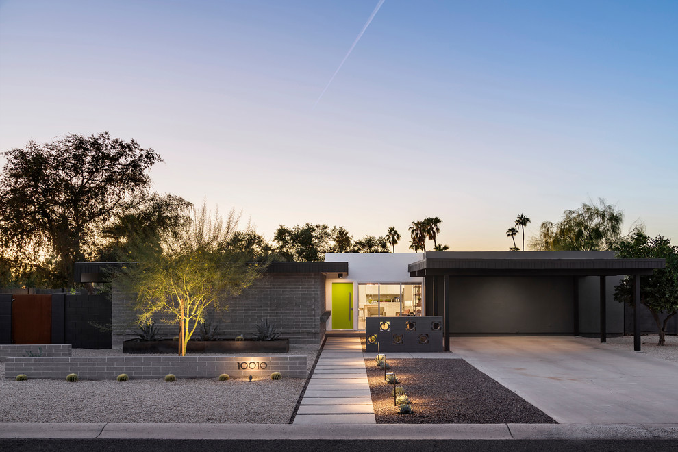 This is an example of a midcentury one-storey house exterior in Phoenix with a flat roof.