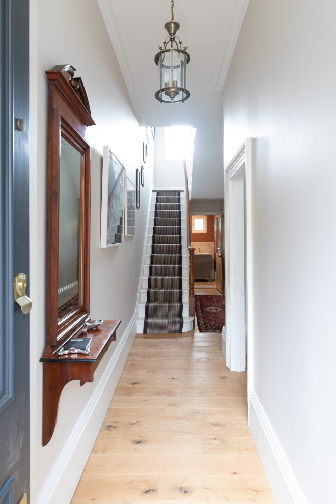 На фото: коридор среднего размера: освещение в викторианском стиле с серыми стенами, светлым паркетным полом и коричневым полом