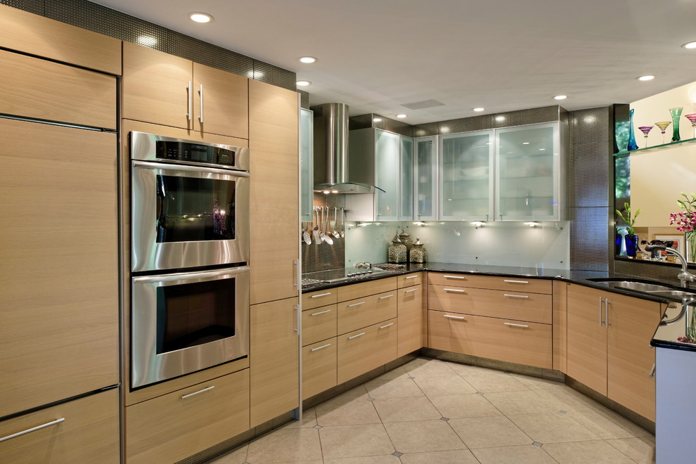 Mid-sized contemporary u-shaped open plan kitchen in New York with a double-bowl sink, flat-panel cabinets, light wood cabinets, solid surface benchtops, stainless steel appliances, ceramic floors, a peninsula, beige floor and brown benchtop.