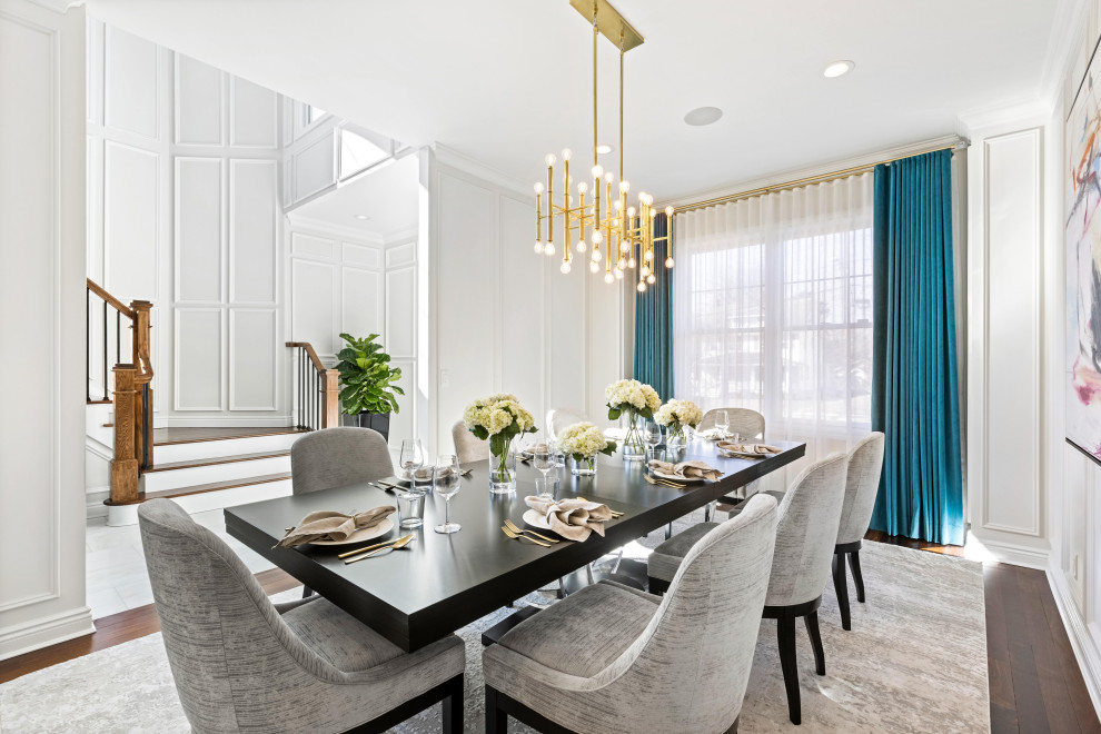 Inspiration for a mid-sized timeless medium tone wood floor, brown floor and wainscoting enclosed dining room remodel in New York with white walls and no fireplace