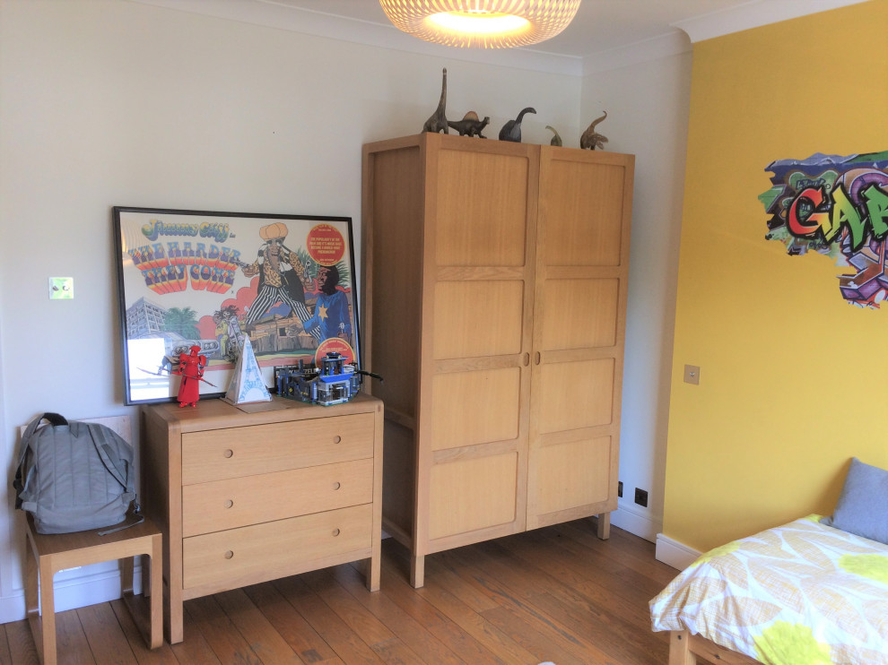 Großes Modernes Kinderzimmer mit Schlafplatz, bunten Wänden, braunem Holzboden und Kassettendecke in London