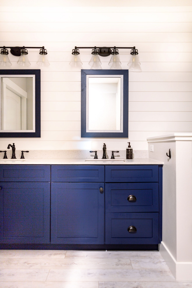 Foto på ett mellanstort lantligt vit en-suite badrum, med luckor med infälld panel, blå skåp, en kantlös dusch, en toalettstol med separat cisternkåpa, vita väggar, vinylgolv, ett integrerad handfat, bänkskiva i onyx, vitt golv och med dusch som är öppen