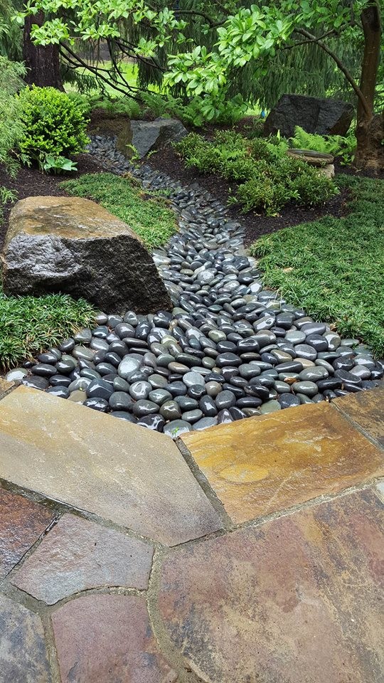 Photo of a small asian garden in Philadelphia with a garden path and river rock.