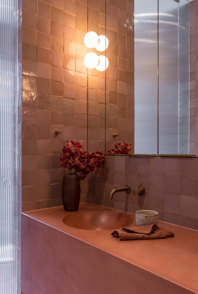 Design ideas for a small contemporary cloakroom in Sydney with a wall mounted toilet, pink tiles, terracotta tiles, pink walls, terracotta flooring, an integrated sink, engineered stone worktops, pink floors, pink worktops and a floating vanity unit.