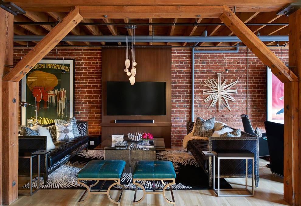 Photo of an industrial open concept family room in Denver with light hardwood floors and a wall-mounted tv.