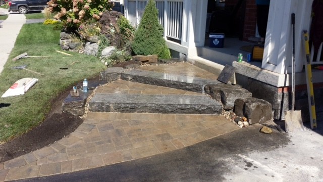 Photo of a mid-sized rustic partial sun front yard concrete paver driveway in Toronto for summer.