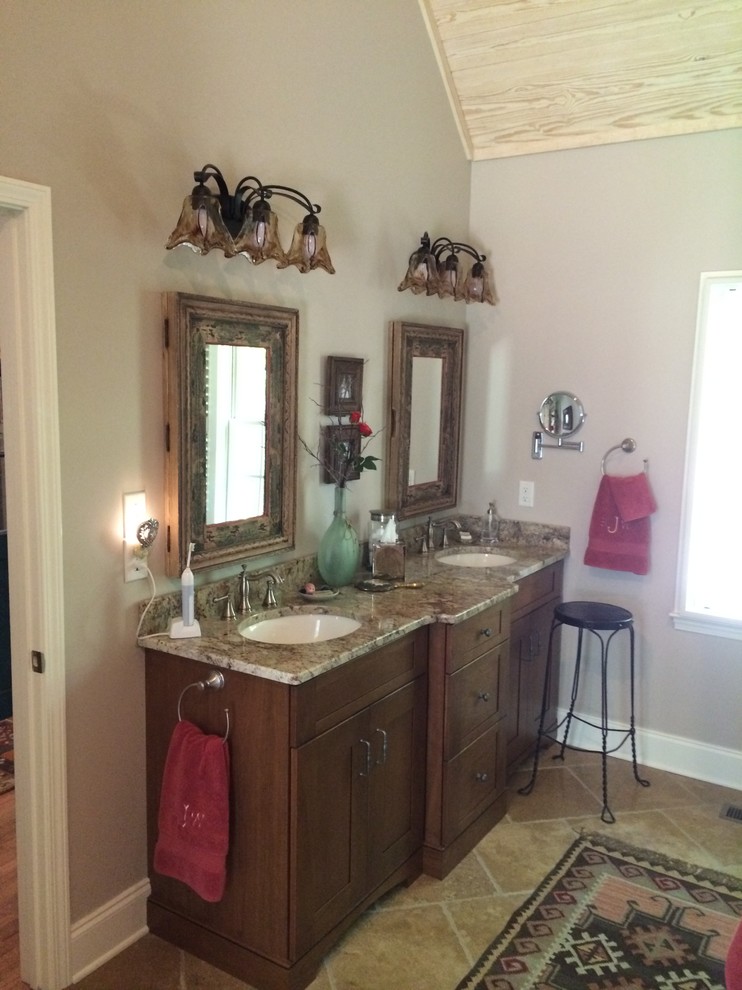 Inspiration for a mid-sized country master bathroom in Other with an undermount sink, furniture-like cabinets, medium wood cabinets, granite benchtops, a double shower, a two-piece toilet, brown tile, stone tile, grey walls and travertine floors.