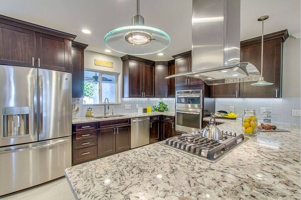 Eat-in kitchen - mid-sized transitional u-shaped dark wood floor eat-in kitchen idea in Phoenix with a double-bowl sink, raised-panel cabinets, dark wood cabinets, wood countertops, white backsplash, subway tile backsplash, white appliances and no island
