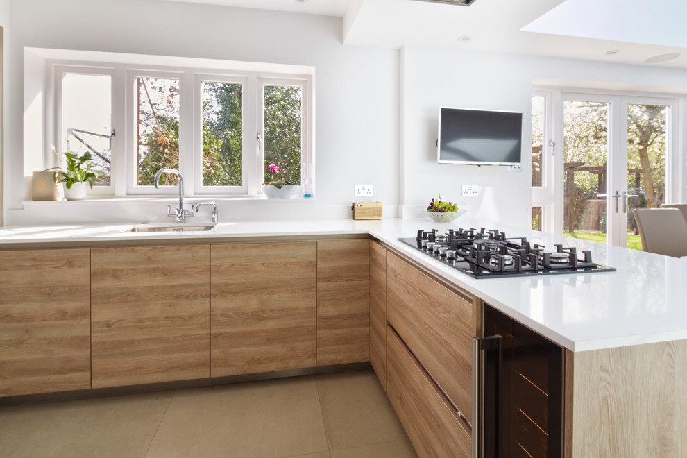 Photo of a mid-sized scandinavian open plan kitchen in Hertfordshire with light wood cabinets.