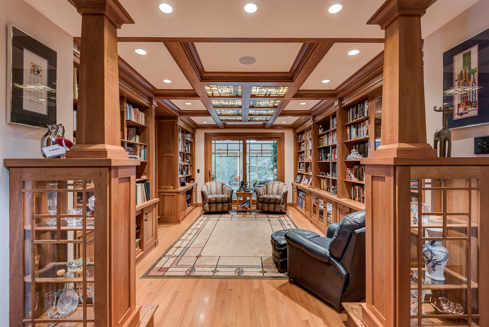 Large arts and crafts open concept living room in Chicago with beige walls, light hardwood floors, a library, no fireplace and no tv.