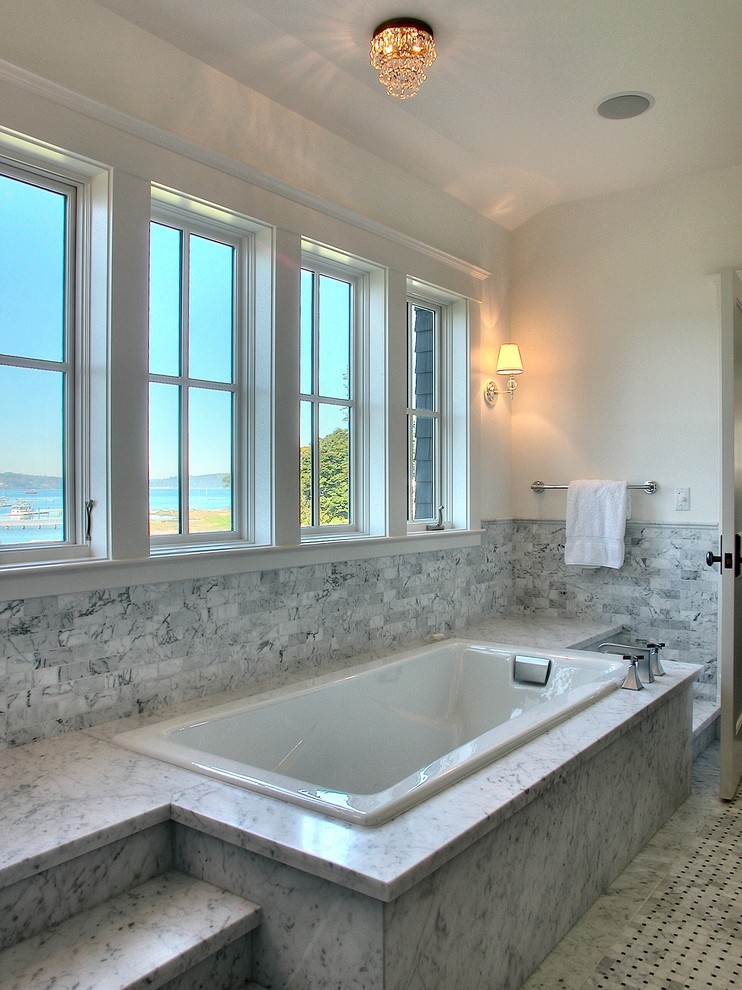 Photo of a traditional bathroom in Other with a drop-in tub and green tile.