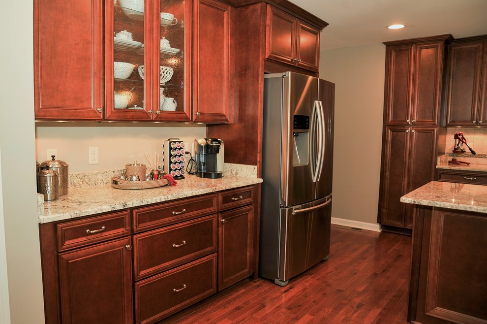 Eat-in kitchen - mid-sized transitional u-shaped medium tone wood floor eat-in kitchen idea in Birmingham with a double-bowl sink, flat-panel cabinets, medium tone wood cabinets, granite countertops, beige backsplash, stone tile backsplash, stainless steel appliances and a peninsula