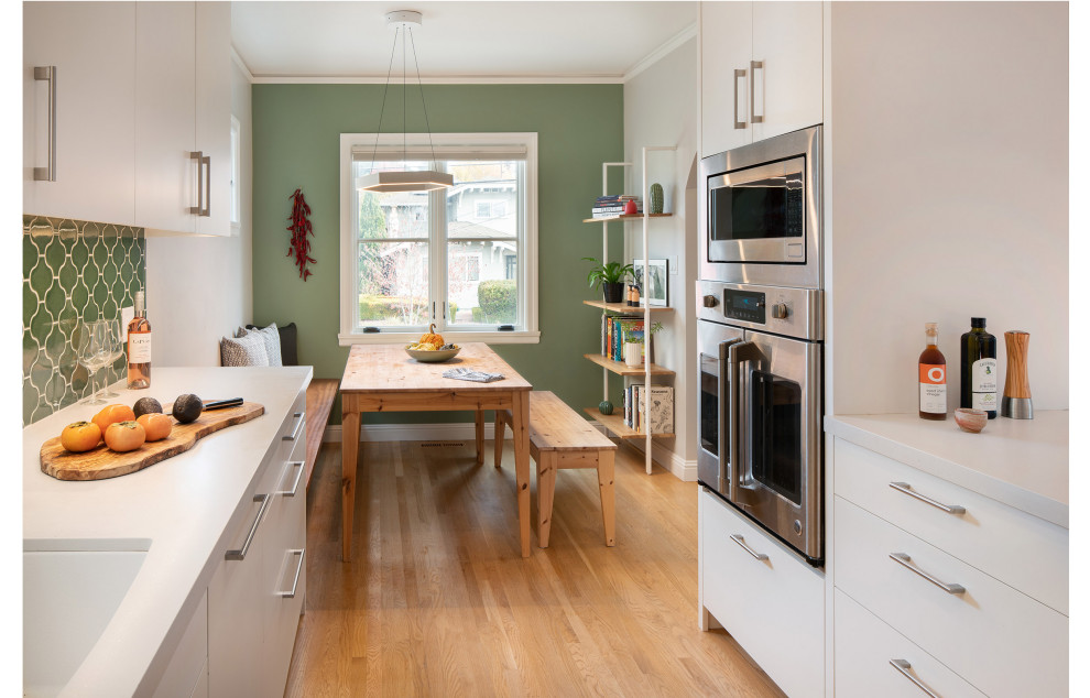Ispirazione per una cucina parallela contemporanea chiusa con lavello da incasso, ante bianche, paraspruzzi verde, parquet chiaro e pavimento marrone