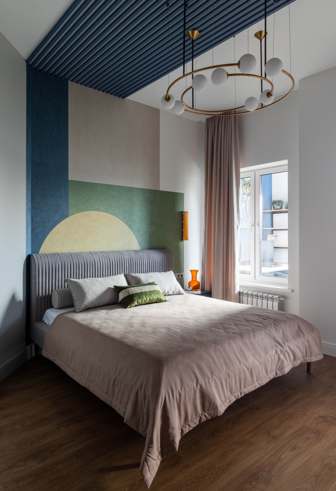 Modelo de dormitorio contemporáneo con paredes multicolor, suelo de madera en tonos medios y suelo marrón