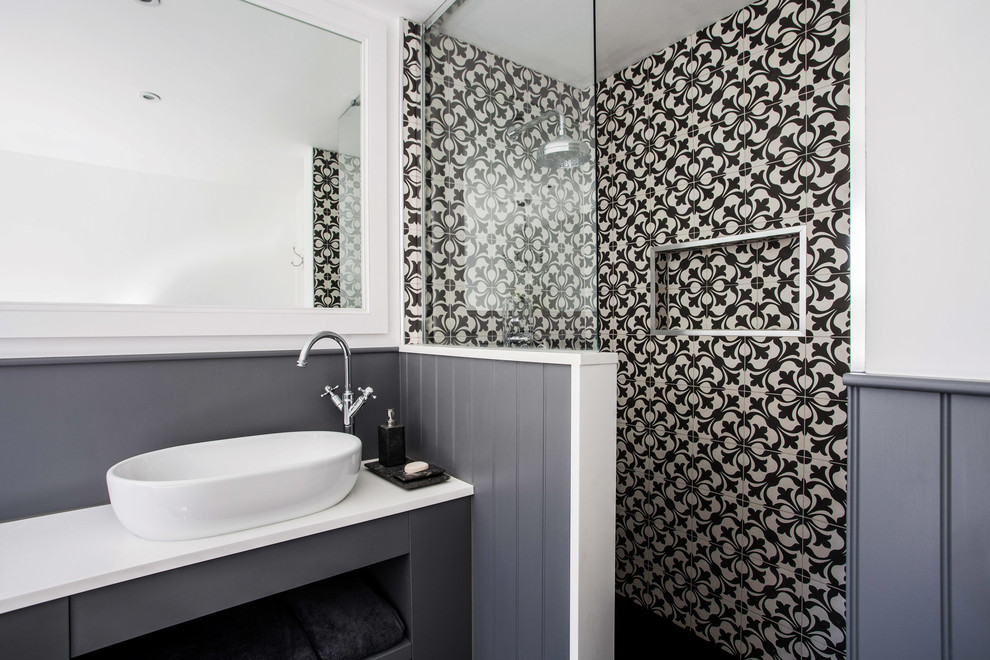 Photo of a mid-sized contemporary kids bathroom in Kent with flat-panel cabinets, grey cabinets, a freestanding tub, a corner shower, a wall-mount toilet, black and white tile, white walls, dark hardwood floors, a drop-in sink, quartzite benchtops, an open shower and white benchtops.