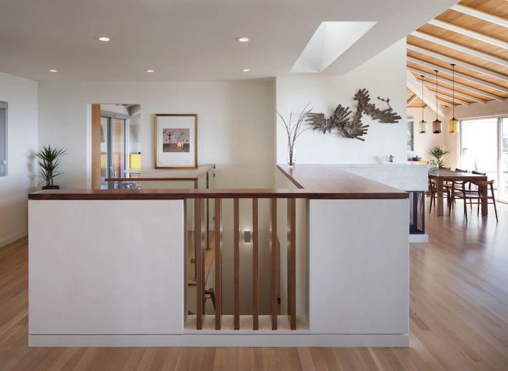 Design ideas for a mid-sized modern wood l-shaped staircase in San Francisco with wood risers and glass railing.