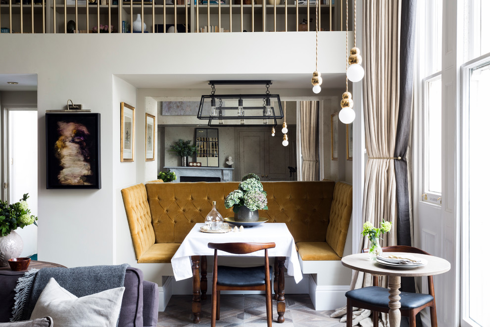 Inspiration for a transitional open plan dining in London with white walls and light hardwood floors.